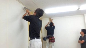 クロス貼りを行なう管理部スタッフ