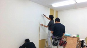 クロス貼りを行なう管理部　今泉課長